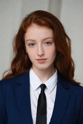 Redhead woman in navy suit and tie