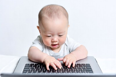 Asian baby typing on laptop