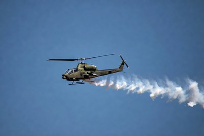 Military helicopter flying with smoke trail