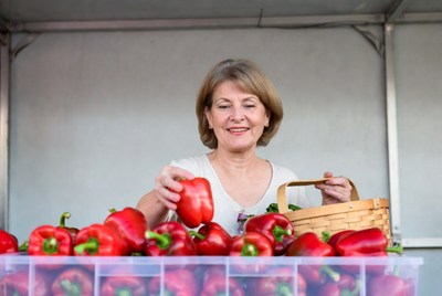 Woman holding red peppers at market