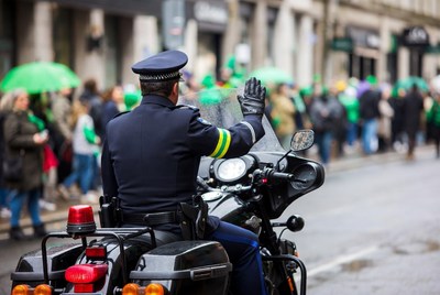 Policeman waving on motorcycle in St. Patrick's parade