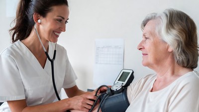 Nurse checking elderly woman's blood pressure