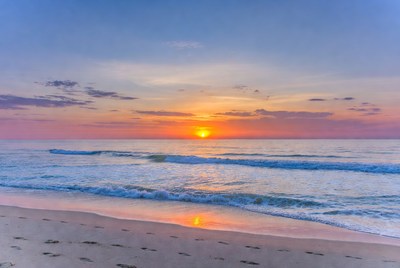 Sunset over beach with footprints