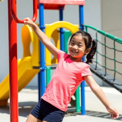 Asian girl climbing playground bars