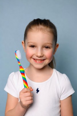 Girl holding rainbow toothbrush
