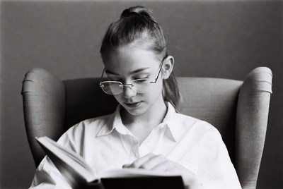 Girl reading book in armchair