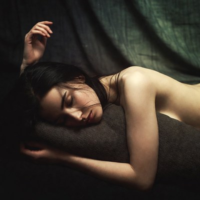 Nude Asian woman sleeping on fabric