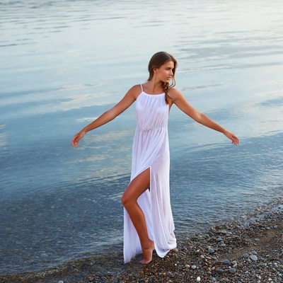 Woman in white dress by lake