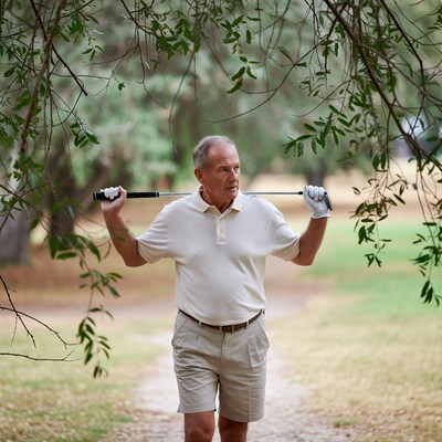 Senior man holding golf club outdoors