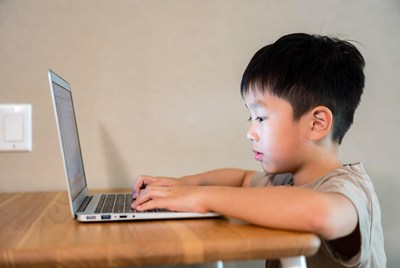Asian boy typing on laptop