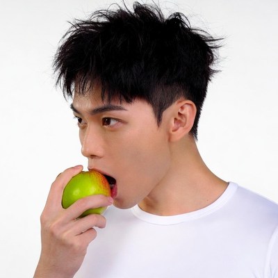 Asian man eating green apple