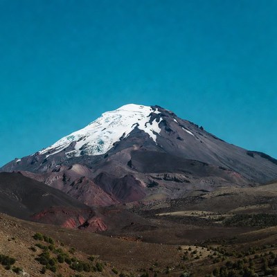 Snow-capped volcano under blue sky