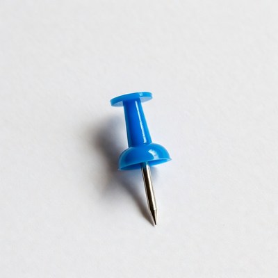 Blue push pin on white background