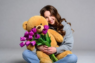 Woman hugging teddy bear with tulips