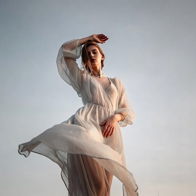 Woman in flowing white dress posing