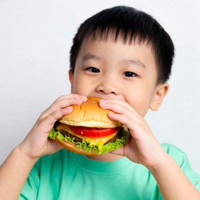 Asian boy eating burger