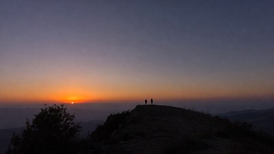 Silhouettes on mountain at sunset
