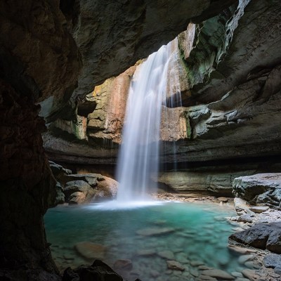 Waterfall cascading into cave pool