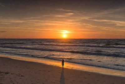 Woman standing on beach at sunset