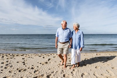 Elderly couple walking on beach