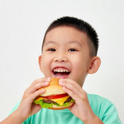 Asian boy eating burger