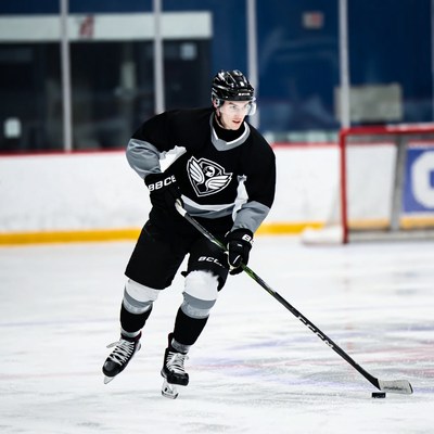 Young man skating with hockey stick