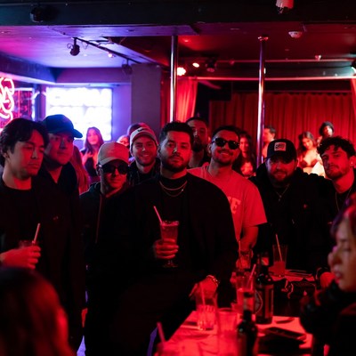 Diverse group at neon-lit strip club bar