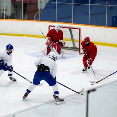 Hockey players shooting on goalie