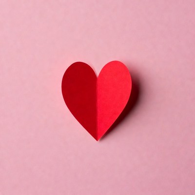 Red paper heart on pink background