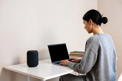 Asian woman typing on laptop at desk