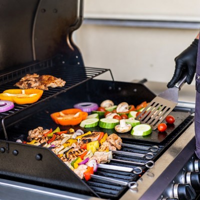 Person grilling vegetables and meat