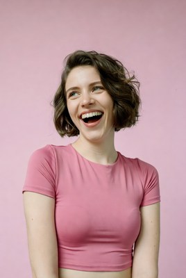 Woman laughing on pink background
