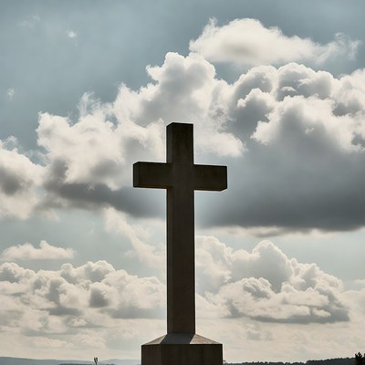 Large concrete cross against cloudy sky