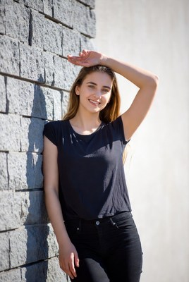 Smiling woman leaning against brick wall