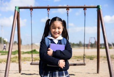 Asian girl in school uniform holding book on swing