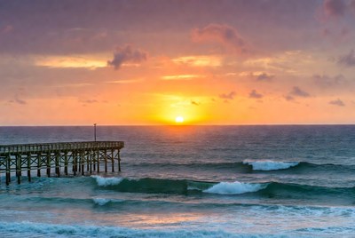 Pier at Sunset Over Ocean Waves