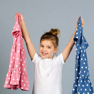 Girl holding pink and blue dresses