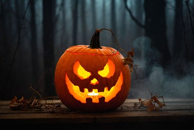 Lit Jack-o'-lantern in foggy forest