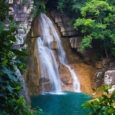 Waterfall cascading into turquoise pool