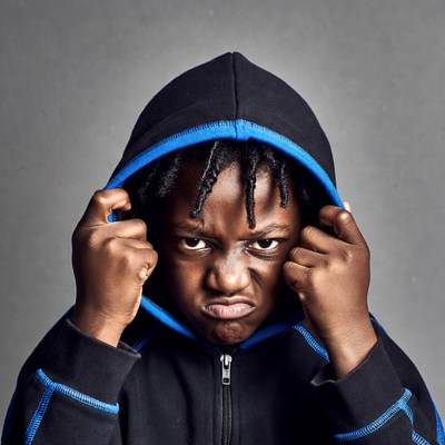 African boy glaring in blue hoodie