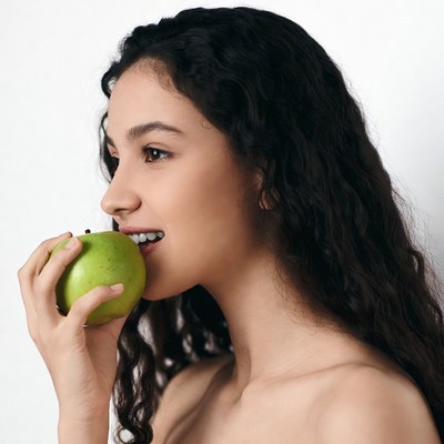 Woman biting green apple