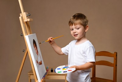 Boy painting on easel