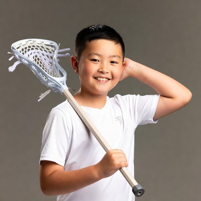Asian boy holding lacrosse stick
