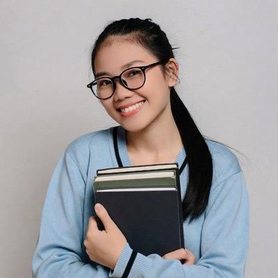 Asian girl holding books in school uniform