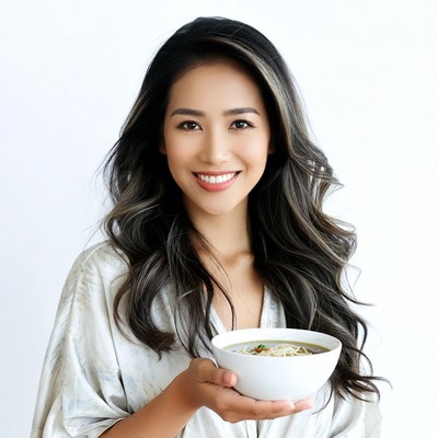Asian woman holding noodle bowl