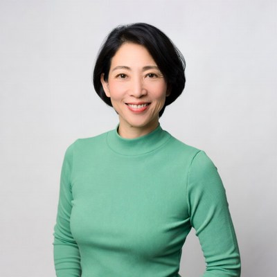 Asian woman smiling in green turtleneck