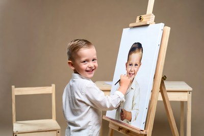 Boy painting self-portrait on easel