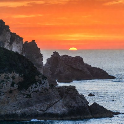 Sunset over rocky cliffs and ocean