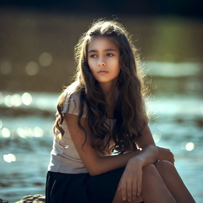 Girl sitting by lake
