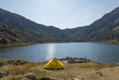 Yellow tent by mountain lake